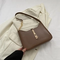 Minimalistische bruine vintage onderarmtas met gouden sluiting op een blazer - Bruin