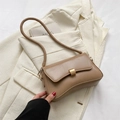 Borsa sottobraccio retrò kaki con fibbia dorata presentata su un blazer beige - Cachi