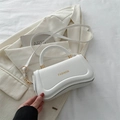 Minimalistische weiße Ledertasche mit geschwungenem Design und goldener Fashion-Schrift - Weiß