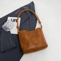 Braune Retro-Eimertasche mit geprägtem Schriftzug und dünnen Riemen für einen Vintage-Look - Braun PU