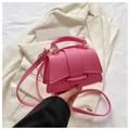 Detailaufnahme der rosa Kunstledertasche mit Lychee-Struktur und Klappverschluss - Rosa