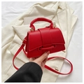Detail der roten Handtasche aus Kieselleder mit goldenen Metallteilen und Tragegriff - Rot