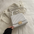 White quilted crossbody bag with vertical stitching and gold-tone metal push lock closure - White