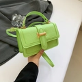 Dettaglio borsa verde neon con texture coccodrillo e chiusura a T in metallo dorato - Verde
