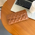 Élégant portefeuille enveloppe en cuir matelassé marron sur un bureau en bois chic - Marron