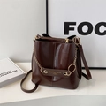 Bolso tipo cubo en marrón oscuro brillante con cadena dorada y correa ajustable fina - Marrón Rojo