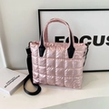 Bolso tote acolchado rosa con asas negras y correa desmontable sobre un escritorio blanco - Rosa
