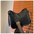 Dettaglio della borsa a mezzaluna in pelle nera con tracolla larga intrecciata - Nero