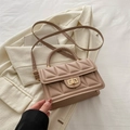 Quilted beige crossbody bag with woven handle and gold twist lock in soft lighting - Khaki