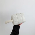 Quilted white nylon clutch bag with top handle shown held by hand in a minimalist style - White