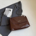 Dark brown glossy leather chain shoulder bag with metal buckle on a gray blazer - Brown