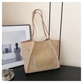 Détail de la texture en paille tressée et patch en cuir sur un grand sac fourre-tout - Kaki