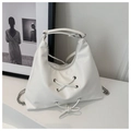 Close-up of white leather tote bag with silver eyelets and criss-cross lace detailing - White