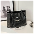Dettaglio borsa tote trapuntata nera con catena e ciondolo con perle e fiori metallici - Nero