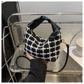 Nahaufnahme der schwarz-weißen Tweed-Handtasche mit goldenen Details und Anhänger - Schwarz