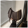 Detalle de bolso hobo de cuero marrón oscuro con cadena dorada y correa lisa - café
