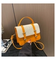 Détail du cuir orange et du tissage en paille crème sur ce sac à main contrasté - Orange