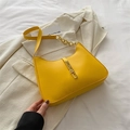 Chic yellow shoulder bag with gold piston clasp on an elegant blazer background - Yellow