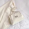 Chic cream white suede shoulder bag featuring a silver bow buckle and chain strap - White