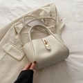 Elegante bolso tote crema con cierre de giro dorado y correa delgada ajustable - Blanco