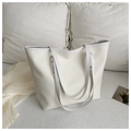 Primer plano del bolso tote beige minimalista con bordes blancos y remaches dorados - Blanco