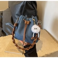 Detalle del bolso de mezclilla azul con asa tejida marrón y colgante de peluche - Azul oscuro