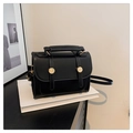 Détail d'un sac à main rectangulaire en cuir noir vintage avec finitions métalliques dorées - Noir