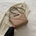 Beige trapezium schoudertas met geometrische textuur en gouden logo op witte achtergrond - Khaki