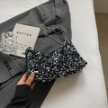 Sac à bandoulière chic à paillettes noires avec chaîne argentée sur un blazer gris chic - Coloré