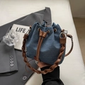 Borsa a secchiello in denim blu con tracolla intrecciata marrone e cordino - Con Ornamento / Blu scuro