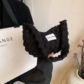 Borsa a spalla nera con trama a bolle ed etichetta LOVE FASHION in un contesto urbano chic - Nero