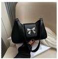 Close-up of a black leather shoulder bag featuring a silver metal bow buckle detail - Black
