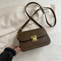 Bolso bandolera vintage marrón oscuro con hebilla dorada sobre tela texturizada - Marrón