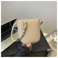 Detalle del bolso bandolera beige con textura de lichi y cremallera plateada ajustable - Caqui