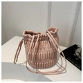 Detailed macro shot of pink drawstring bucket bag with vertical pleated satin texture - Pink