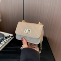 Mini borsa beige trapuntata con tracolla a catena e chiusura a girello dorata, mostrata in mano - Cachi
