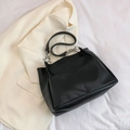 Borsa tote nera minimalista con tracolla a catena su blazer color crema - Nero