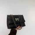 Elegant black shoulder bag with silver bow accent and quilted leather texture - Black
