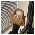 Close-up of khaki quilted handbag featuring a silver bow metal clasp and top handle - Khaki