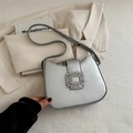 Borsa a spalla a mezzaluna argento con fibbia in strass su sfondo blazer beige - Argento