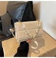 Close-up of cream quilted square bag with gold metal and white resin chunky chain detail - Off White