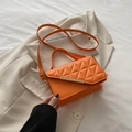 Chic orange crossbody bag featuring geometric triangle quilting and gold metal trim - Orange
