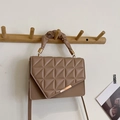 Coffee brown quilted crossbody bag with cloud handle and gold hardware hanging on a wall hook - Khaki