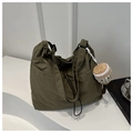 Detail view of olive green drawstring nylon tote with adjustable strap and cupcake charm - Green With Pendant