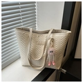 Detail of cream quilted tote bag with V-shaped stitching and a pink plush charm - White With Pendant
