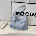 Détail du sac cabas bleu clair avec texture marbrée et bandoulière en chaîne argent - Bleu