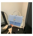 Dettaglio della borsa bicolore azzurro e bianco con chiusura dorata e manico corto - Contrasto Blu e Bianco