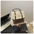 Détail du sac à main vintage montrant les textures mixtes et le logo doré brillant - Gris