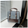 Vue détaillée du sac à main bleu vintage avec rivets dorés et poignées en cuir marron - Bleu