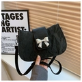 Detalle del bolso de cuero negro con textura y elegante hebilla de lazo plateada - Negro